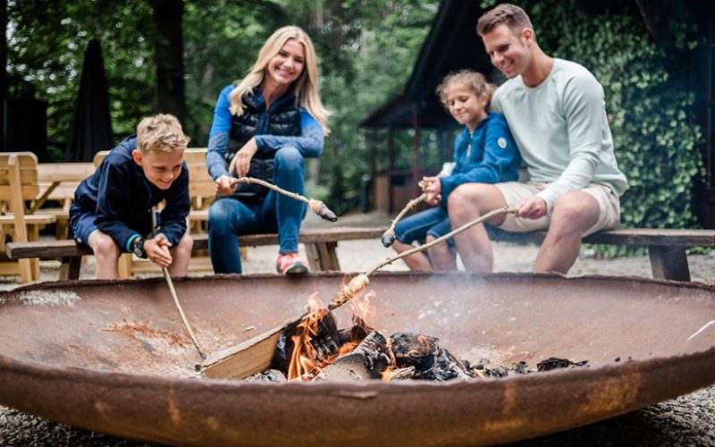 Familie grillt Stockbrot am Feuer
